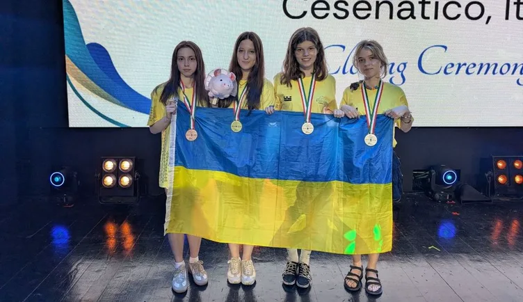Four members of Ukraine's team with the flag on stage at the EGOI 2026 closing ceremony