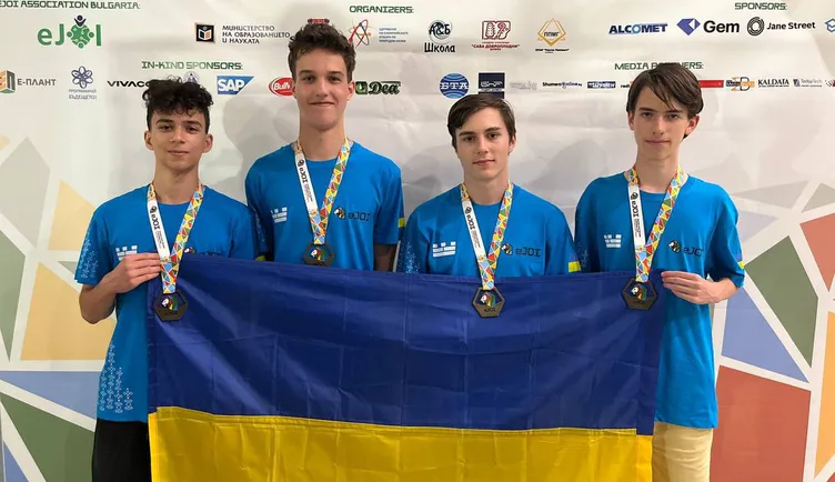 Four members of Ukraine's team with their medals under the EJOI 2025 banner